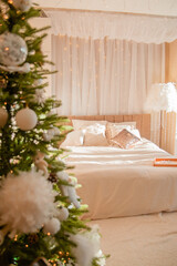 Christmas bedroom early in the morning, Christmas tree with toys in delicate shades. Interior decoration for the holiday.