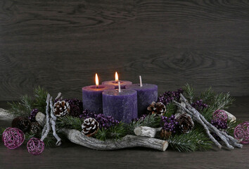 Adventsdekoration: Adventskranz mit zwei lila brennenden Kerzen für den zweiten Advent mit...