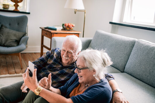 Elderly couple having a video call in the living room