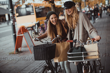 Two young women walking in the city with bikes