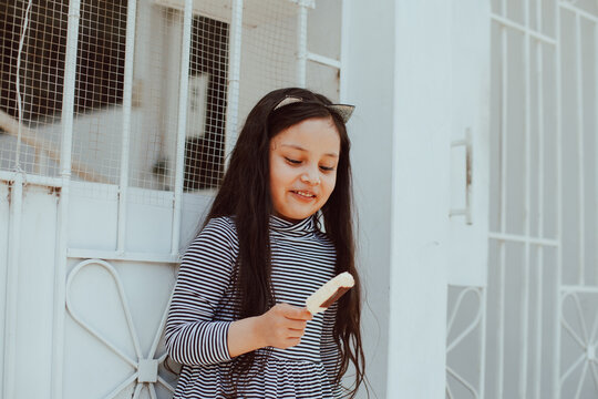 Picture of adorable happy girl eating an ice-cream outdoors. Concept of people, children and lifestyle.