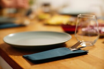 Empty gray plate on a wooden table with silverware.