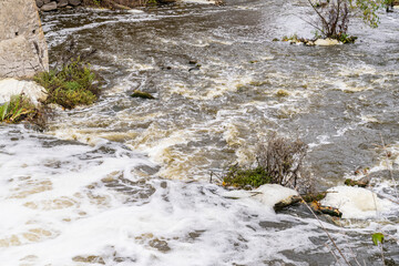 Nature, waterfall rapids. Fast current, splashes, water boils. Foam.