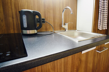 The minimal kitchen design in the modern home includes a hotplate and a cabinet for storage.