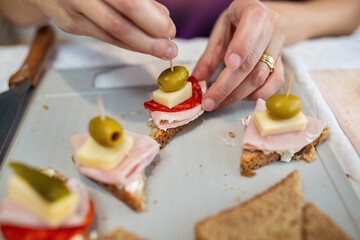 Close up of woman's hand preparing canape.