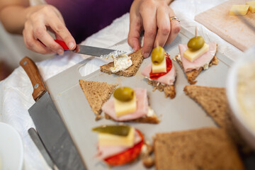 Close up of woman's hand preparing canape.