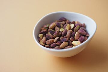 natural Pistachio nuts in a bowl on color background 