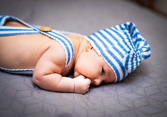 A baby wearing a blue and white striped diaper. Baby in a Stylish Diaper with a Trendy Blue and...