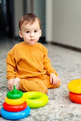 A Playful Toddler Engrossed in His Colorful Toy Collection. A little boy sitting on the floor playing with toys