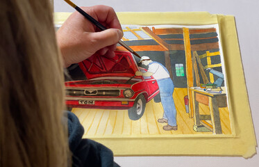 A blonde woman paints a watercolor with her left hand. The watercolor shows a car mechanic standing by the open hood of a red vintage car. The car is parked in a wooden shed.