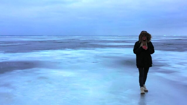 Lake , girl walking on frozen lake, Girl walking on cracked ice of a frozen lake Baikal, Woman walking along the diamond beach in Iceland. Feet on ice, girl walking on frozen lake 