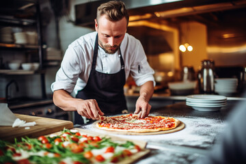 A Male chef makes pizza in a restaurant - obrazy, fototapety, plakaty