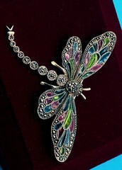 Closeup of a dragonfly brooch with gemstones - obrazy, fototapety, plakaty