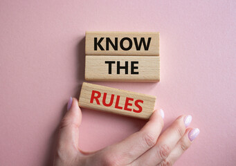 Know the rules symbol. Wooden blocks with words Know the rules. Beautiful pink background. Businessman hand. Business and Know the rules concept. Copy space.