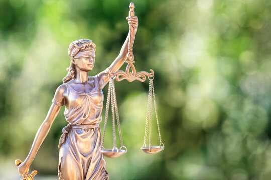 Legal law concept statue of Lady Justice with scales of justice with green background