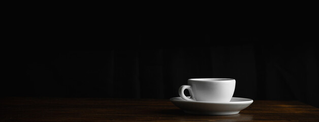 Coffee cup on dark background. Space for text. Banner