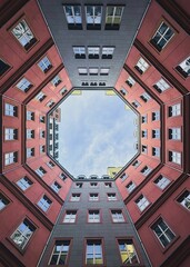 Vertical shot of a red and gray residential building in Berlin.