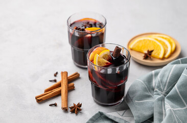Mulled wine with orange, apple  and cinnamon in glasses on a light background. The concept of a...