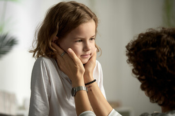 Little boy listening and talking to his mom while she showing her care and supporting him