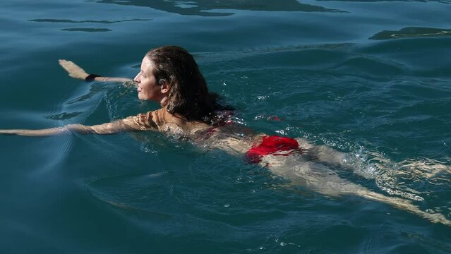 Adult Caucasian Brunette Woman Enjoying Swimming in Bikini in the Sea 