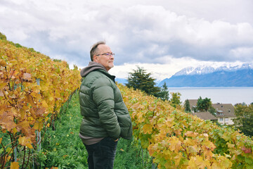 Outdoor portrait of middle age 55 - 60 year old man enjoing nice autumn day in vineyards, healthy and active lifestyle