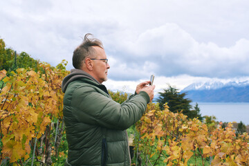 Outdoor portrait of middle age 55 - 60 year old man enjoing nice autumn day in vineyards, healthy...