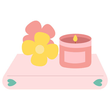 Libro rosa con vela aromática y flores encima