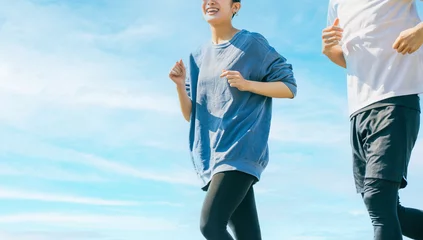 Foto op Plexiglas 青空の下でジョギングをする笑顔の日本人男女 © Trickster*