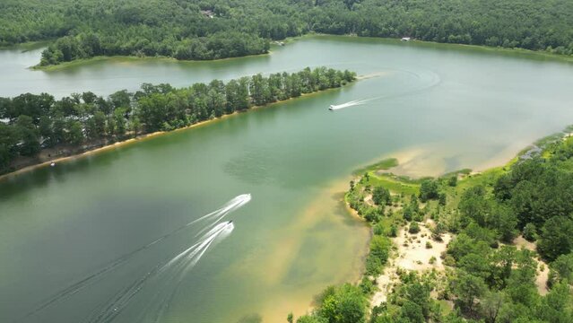 Aerial view of motorboats sailing on a river with tree rows