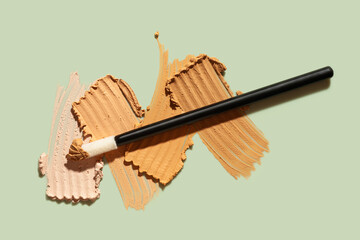 Cosmetic texture set of concealer swatch isolated on green background