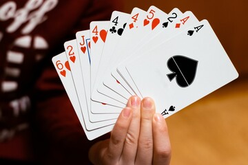 Closeup of person's hands holding the card deck on the table