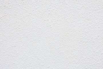 Background of a wall covered with white decorative plaster. Interior decoration of walls in a house using white plaster. A beautiful clean wall plastered with uneven stripes and droplets.