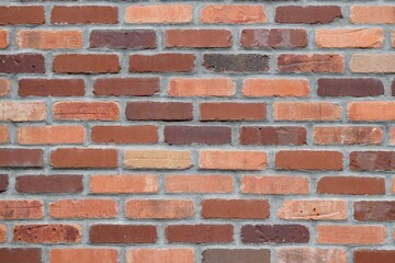 Obraz premium Weathered brick wall with a textured surface and cracks visible on the surface.