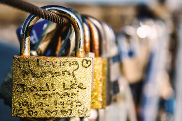 Close-up shot of a collection of three padlocks with a love message inscribed on one of them - Powered by Adobe