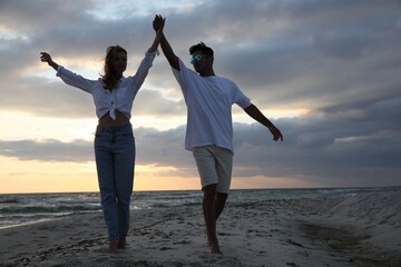Fototapeta premium Happy couple dancing on beach at sunset