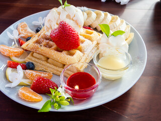 waffle with ice cream and fruits on wood table, top view
