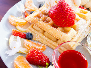 waffle with ice cream and fruits on wood table, top view