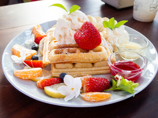 waffle with ice cream and fruits on wood table, top view