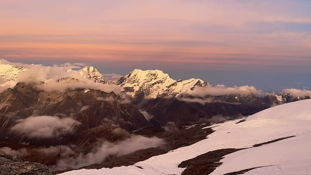 Beautiful Sunset time view time lapse video from Mera peak High Camp at cca 5750m with running foggy clouds with small Kangchenjunga third-highest mountain in the world 8586 m on horizon.
