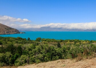 Scenic view of the lake Sevan with the hills hidden in the clouds