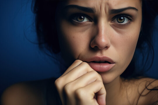 gros plan sur un visage de femme inqui&egrave;te la main devant sa bouche