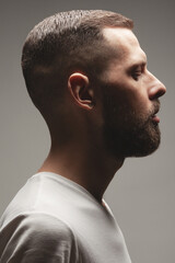 Male beauty concept. Profile portrait of charismatic active 30-year-old man posing over gray...