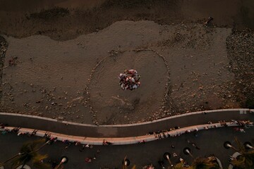 Aerial view of people doing extreme tricks on a sandy beach