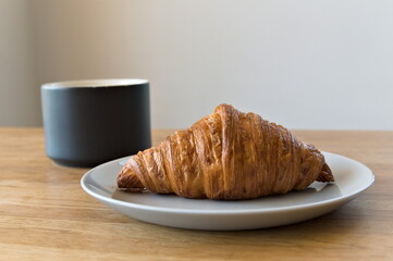breakfast view of croissant and a cup of coffee