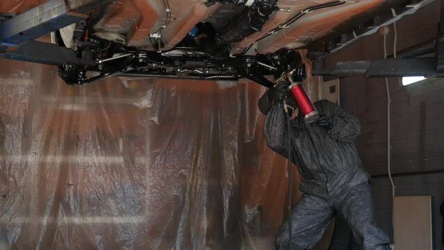 Treatment of the bottom of the car with an anti-corrosion agent. Car on the lift