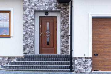 Designer entrance door to a country house. Modern design. luxurious exterior. Facade of a modern building with modern doors.