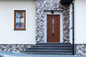 Designer entrance door to a country house. Modern design. luxurious exterior. Facade of a modern building with modern doors.