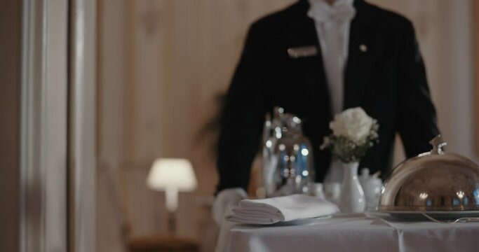 Man bringing a room service cart down the hall