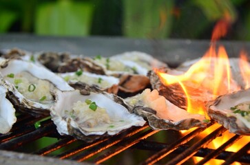 Variety of freshly cooked oysters on a hot grill.