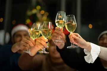 close up glasses of clinking glasses of champagne with lighting. Dinner party with drinking of champagne. hands holding clear glass with alcohol in yellow shine reflect.